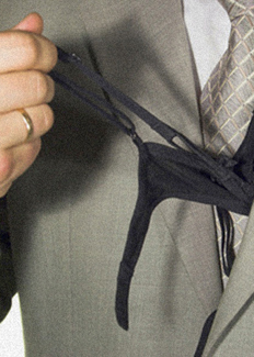Man pulling female underwear from his suit jacket inside pocket